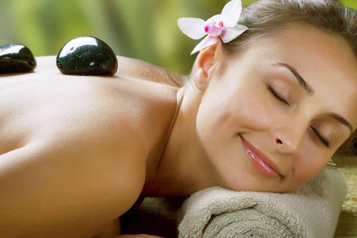 Warm stones resting on a guest's back during a hot stone massage